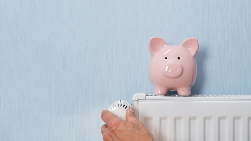 Stock image of a piggy bank on top of a radiator